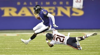 Robert Griffin III, quarterback de los Ravens de Baltimore, elude a Michael Joseph, de los Bears de Chicago. Ravens superan a Bears en Canton