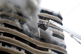 Las llamas y el humo se propagaron rápidamente y algunos vecinos quedaron atrapados en una escalera. (AP)