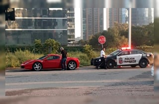 En la fotografía se ve al 'Tuca' que abre la portezuela de su auto Ferrari, mientras que un policía camina de regreso a la patrulla. Ambos se dan la espalda. (Especial)