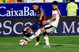 El centrocampista francés del Huesca, Serdar Gurler (i), golpea el balón ante el jugador del Rayo, Alex Moreno.