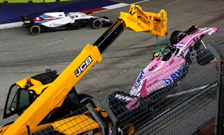 Una grúa se lleva el monoplaza del francés Esteban Ocon luego del accidente que tuvo con su coequipero Sergio 'Checo' Pérez en la primera vuelta del Gran Premio de Singapur.