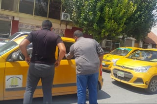 Rodeado. Estos dos choferes de taxis 'cinqueros', que cubren la ruta bulevar Independencia, exigen a chofer del taxi que les entregue lo correspondiente a las personas que transporta. (EL SIGLO DE TORREÓN)