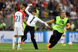 Un guardia de seguridad saca a una mujer de la cancha tras haber ingresado en la final de la Copa del Mundo entre Croacia y Francia.