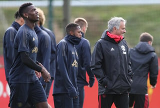 El entrenador del Manchester United, José Mourinho (d), y el jugador Paul Pogba (izq) asisten a una sesión de entrenamiento en la ciudad deportiva de Carrington, en Manchester, ayer.