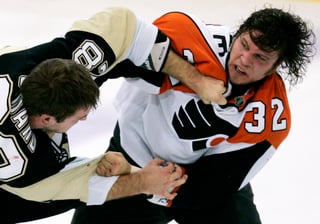 Eric Godard, de los Penguins de Pittsburgh, pelea con Riley Cote, de los Flyers de Filadelfia.