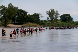 Paso a paso. La segunda caravana de migrantes, en su mayoría hondureños, cruzan a pie el río Suchiate por una parte que no es muy profunda. (EFE)