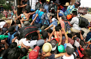 En marcha. Decenas de migrantes centroamericanos, integrantes de la caravana que espera llegar a Estados Unidos, intentan subir a un camión en Isla, Veracruz, para continuar su recorrido a través de México. (AP)