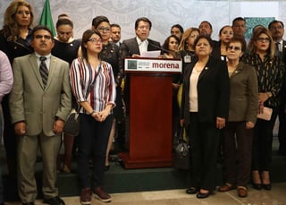 Apoyo. Entre las curules, legisladores tratan de asistir a la diputada CarmenMedel tras recibir la noticia del asesinato de su hija. (EL UNIVERSAL)