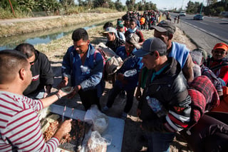 Apoyo. Un hombre ofreció tacos a migrantes de la caravana en Mexicali. (EFE)