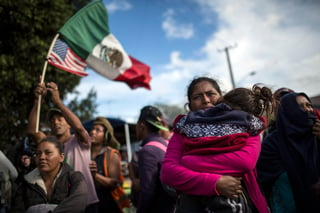 Tensión. La hondureña Leticia Núñez abraza a su hija durante la marcha pacífica que llevaron a cabo el jueves en Tijuana los inmigrantes de la caravana que pretende cruzar a Estados Unidos. (AP)
