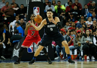 Nikola Vucevic, del Magic de Orlando, recibe un balón frente a Justin Holiday, de los Bulls de Chicago.