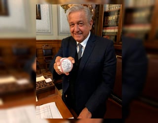 Andrés Manuel López Obrador posa con la pelota que le regaló Julio Urías. (Especial)