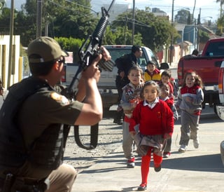 Violencia. Policías ponen a salvo a un grupo de niños, durante un tiroteo en Tijuana en 2008. (EFE)
