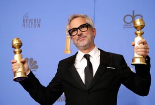 Ganador. Alfonso Cuarón con sus dos Globos de Oro, por Mejor Película Extranjera y Mejor Director. (EFE) 
