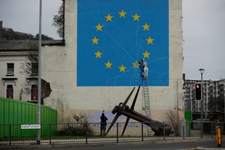 Obra. Un mural del artista Banksy de un hombre cincelando una estrella de la bandera europea. (AP)