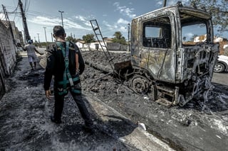 Atentados. Un hombre camina frente a un vehículo quemado tras un ataque en Fortaleza, Brasil. (EFE)