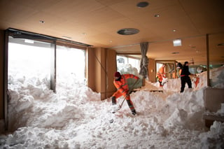 Complica. Personas retiran la nieve que se metió por una avalancha en el hotel Saentis en Suiza.