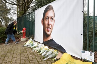 Ramos de flores y otros tributos desplegados cerca de una foto del futbolista argentino Emiliano Sala afuera del predio de entrenamientos del club francés Nantes. (AP) 