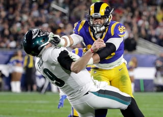 El defensive end de los Rams, Aaron Donald, golpea al quarterback de Filadelfia, Nick Foles, durante un partido pasado.