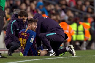 El delantero argentino del FC Barcelona, Leo Messi, atendido por los fisios del equipo blaugrana durante el encuentro de la jornada 22.