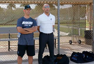 Jorge Posada (i) conversa con Derek Jeter, director general de los Marlins de Miami, durante un entrenamiento.
