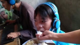 Las imágenes de la mujer alimentando al chico de 13 en la boca  mientras éste no despega su visita del videojuego se viralizaron en redes sociales.  