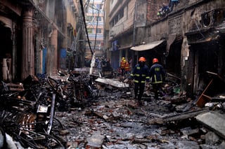 Restos. Bomberos trabajan entre edificios que ardieron en un incendio nocturno en Daca.