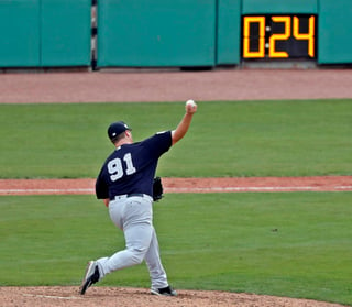 El reloj de lanzamientos se observa mientras que el pitcher de los Yankees, Cale Coshow, lanza al plato.