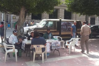 Se instalaron mesas en la Plaza de Armas de Torreón para levantar firmas en contra el aumento del transporte. (ROBERTO ITURRIAGA)