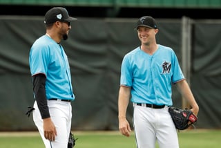 Los lanzadores Trevor Richards (d) y Héctor Noesí de los Marlines de Miami charlan ayer durante una práctica de la pretemporada del equipo.
