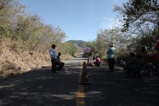 El lunes un grupo de 12 pobladores indígenas de Santa María Ostula, municipio de Aquila, fueron encadenados a postes de madera por comuneros en el centro de control de Xayacala. (TWITTER)