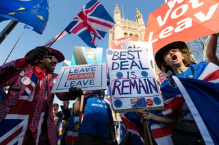Un hombre a favor del Brexit (Izq.) y una mujer en contra se manifestaron ayer en el exterior del palacio de Westminster.