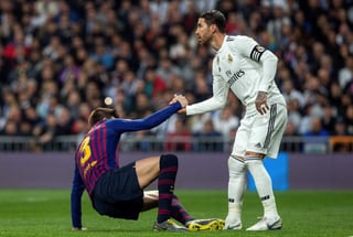 Sergio Ramos apoya a Gerard Piqué para ponerse en pie durante el clásico español del pasado miércoles en la Copa del Rey. (Especial)