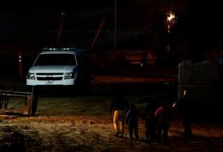 Unos migrantes son escoltados por agentes de la Patrulla Fronteriza de EUA luego de ser detenidos tras cruzar la frontera. (AP)