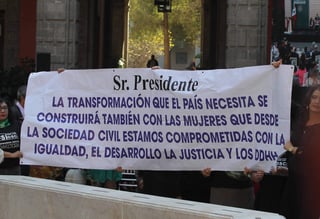 Previo a la conmemoración del Día Internacional de la Mujer, en Palacio Nacional, un grupo de mujeres desplegó una lona ante el presidente Andrés Manuel López Obrador. (NOTIMEX)