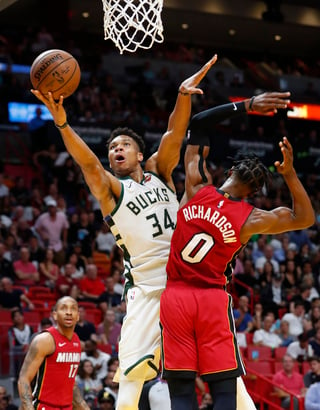 El ala-pívot de los Bucks, Giannis Antetokounmpo (34), se cuela hacia la canasta sobre la marcación del escolta del Heat, Josh Richardson.