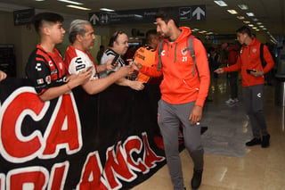 El delantero Eduardo Herrera saluda a algunos aficionados del Necaxa a su llegada al aeropuerto de Torreón.