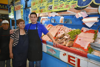 La señora Mayela Diosdado apoya a su hijo Juan en el trabajo diario de la pescadería, esto tras la muerte de su papá el año pasado.