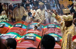 Sacerdotes queman incienso sobre féretros vacíos cubiertos con la bandera de Etiopía durante un funeral por las víctimas del accidente de Ethiopian Airlines en la catedral de Adís Abeba, Etiopía.