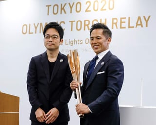 Tokujin Yaoshioka (i), diseñador de la antorcha olímpica de los Juegos de Tokio 2020, y Tadahiro Nomura (d), tricampeón olímpico de judo, posan durante la ceremonia de presentación de la antorcha.