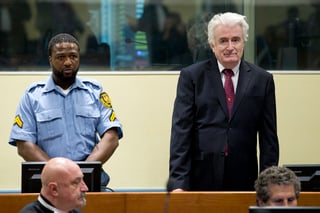 El expresidente serbobosnio Radovan Karadzic escucha de pie la ratificación de su sentencia de 40 años de cárcel. (AP)