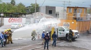 Mientras bomberos enfría el tanque de gas LP para reducir el riesgo de incendio y explosión, paramédicos extraen al conductor y a su acompañante, supuestamente lesionados. (EL SIGLO COAHUILA)

