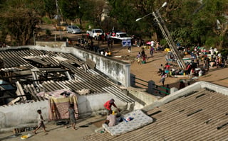 Familias desplazadas colocan colchones en el tejado de un edificio en el distrito de Buzi. (AP)