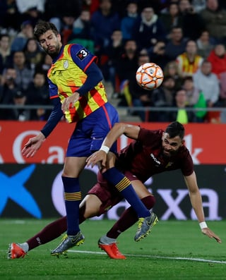 Gerard Piqué compite por el balón con el defensa de la selección de Venezuela, John Chancellor, durante un juego amistoso en el estadio Montilivi en Girona.
