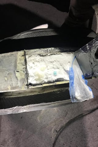 Policías aseguran 24 paquetes ocultos en los rines de un auto.