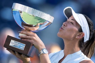 La tenista española Garbiñe Muguruza posa con el trofeo de campeona tras un partido contra la bielorrusa Victoria Azarenka.