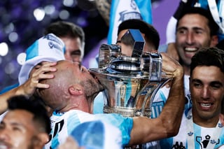 Lisandro López (centro) besa el trofeo de la Superliga Argentina que consagra a Racing como campeón de Liga. (Jam Media)