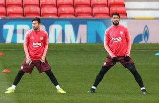 Leo Messi (i) y Luis Suárez asisten a una sesión de entrenamiento ayer en el estadio Old Trafford.