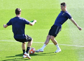 El delantero portugués de la Juventus Cristiano Ronaldo (d) y el defensa italiano Daniele Rugani ayer, en una sesión de entrenamiento.