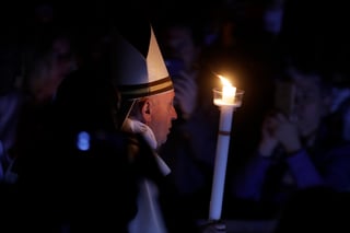 El papa Francisco sostiene una vela mientras preside una ceremonia solemne de vigila de Pascua en la Basílica de San Pedro.